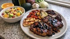 Χοιρινές μπριζόλες στη σχάρα με βαλσαμικό, ψητά λαχανικά, ταλαγάνι και κους κους με φρούτα