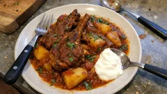 Αρνίσια παϊδάκια ταβά με κόκκινη σάλτσα και πατάτες — λιώνουν στο φούρνο