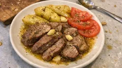 Αρνάκι στο ταψί με ντομάτα και σκόρδο – λιώνει και οι πατάτες μελώνουν